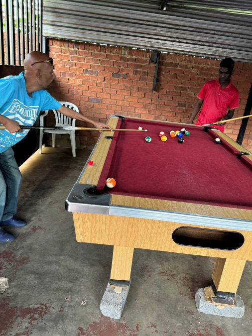 Two individuals playing pool